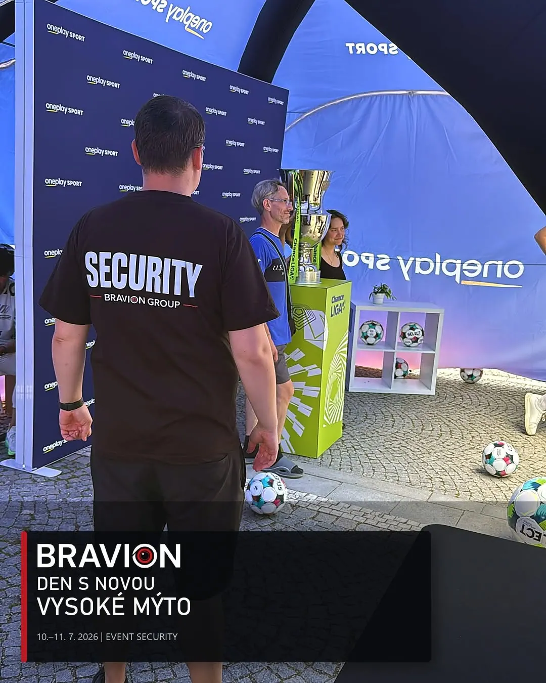 Pracovník Bravionu u fotografické zóny s fotbalovou trofejí ve Vysokém Mýtě