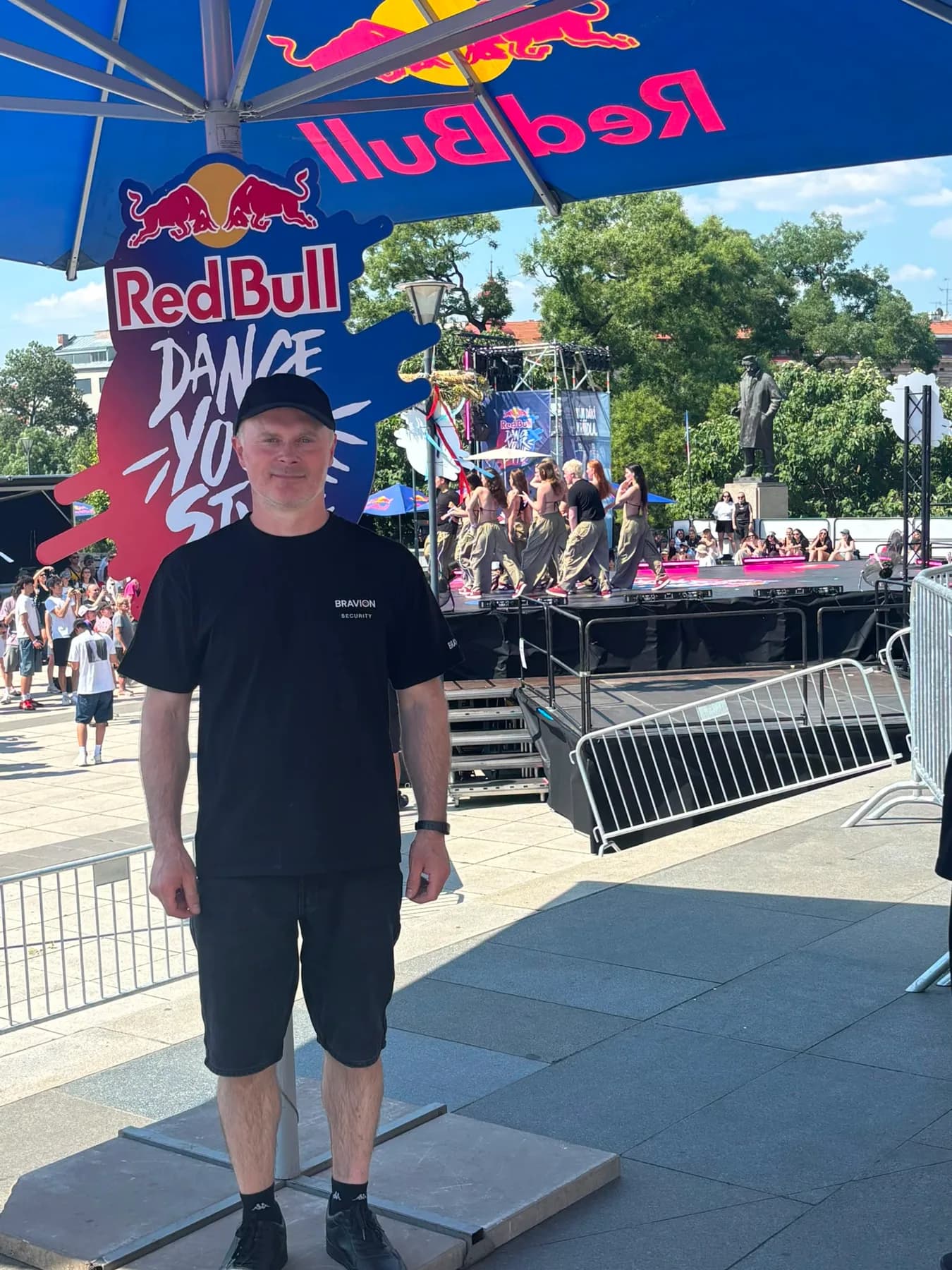 Pracovník Bravion před značkou Red Bull Dance Your Style s tanečníky na pódiu