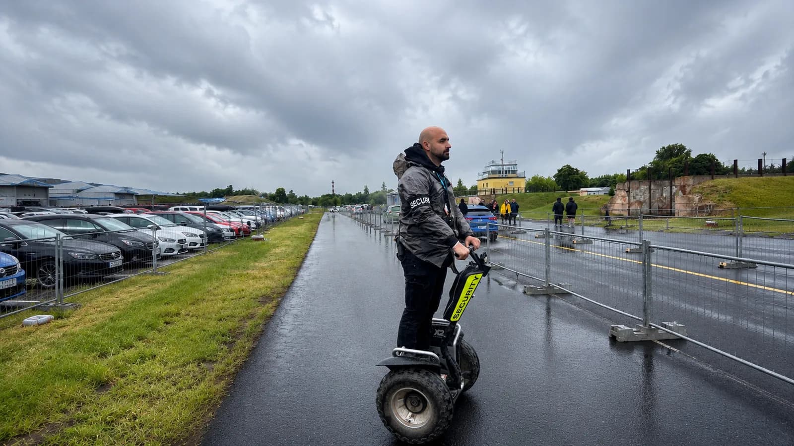 Security pracovník Bravionu u výjezdového režimu dopravy v deštivém počasí